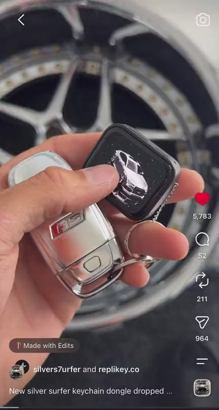 Custom car keychain held in front of a car